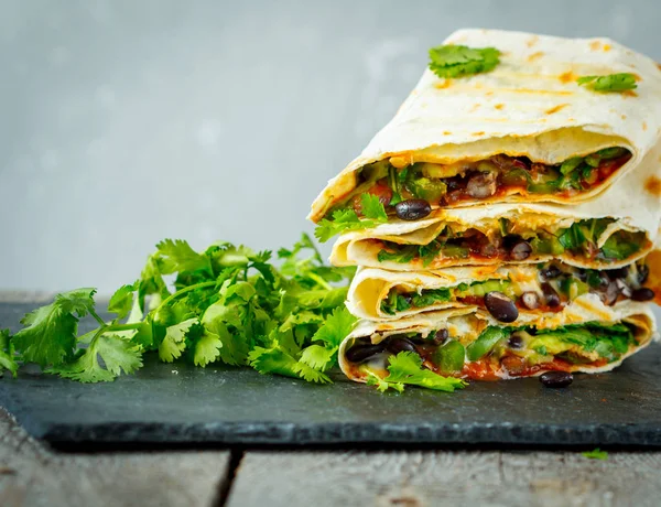 Burritos vegetarianos envolve feijão, abacate e queijo em uma ardósia — Fotografia de Stock