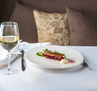 Ton balıklı sebze bir yastık üzerine beyaz tabakta servis edilir