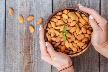 Bir ahşap kase çiğ badem fındık.