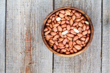 Bir ahşap kase çiğ fıstık.