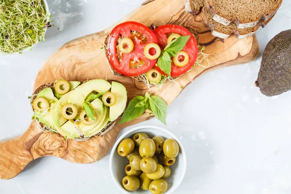 Veganska smörgåsar med avokado, tomater och groddar. — Stockfoto