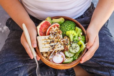 Buda kase soya peyniri, brokoli ve sebze elinde bir