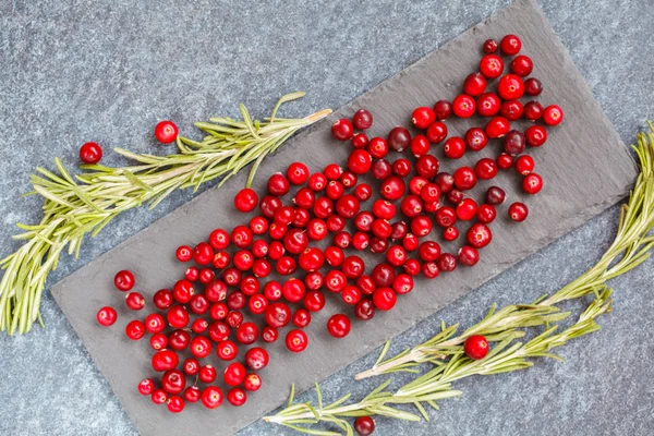 Taze kırmızı kızılcık ve biberiye kayrak üzerine