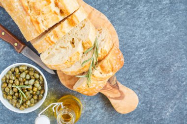 Karanlık bir arka plan üzerinde otlar ile taze ciabatta