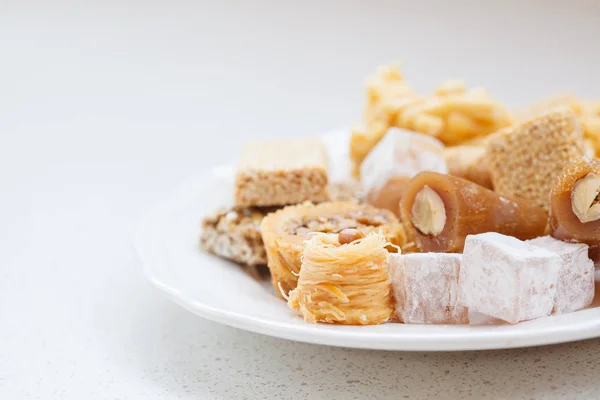 白色盘子里的蜂蜜东方糖果品种 — 图库照片