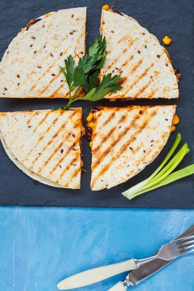 Pieces of quesadilla on slate, blue background — Stock Photo, Image
