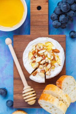 Tatlım, fındık ve bir tahta üzerinde meyve ile Brie peyniri (camembert) 