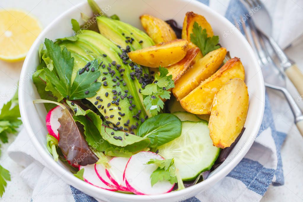 Buddha bowl rainbow salad with baked potatoes, avocado, radish a