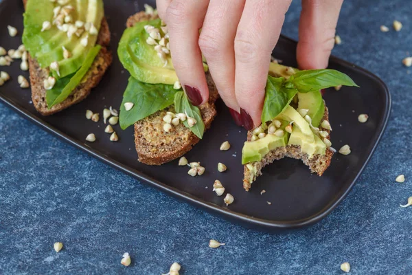 Avocado-Sandwich mit Basilikum und Sprossen aus grünem Buchweizen auf einem — Stockfoto