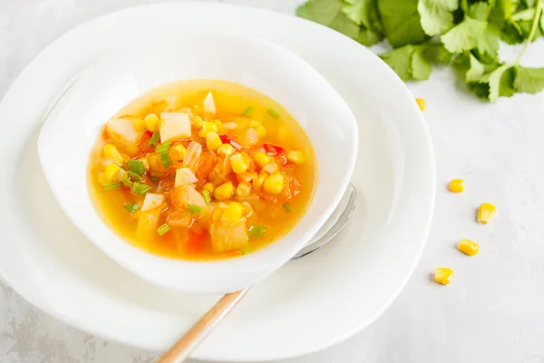 Healthy spring vegetable corn soup in a white plate. Vegan Healt