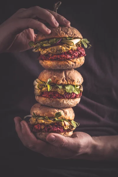 Vegan healthy burgers in mans hands.