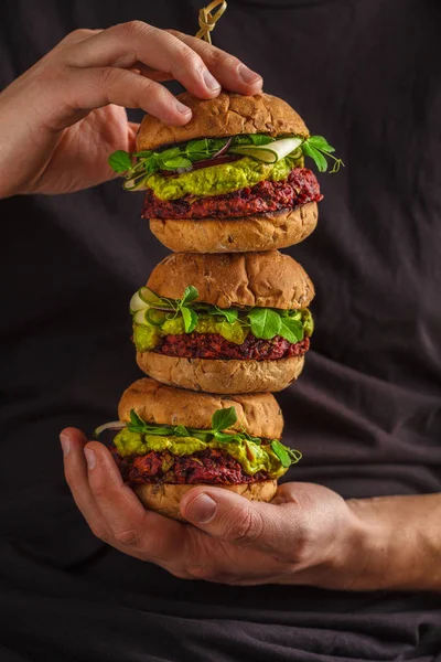 Веганские здоровые гамбургеры в руках мужчин . — стоковое фото