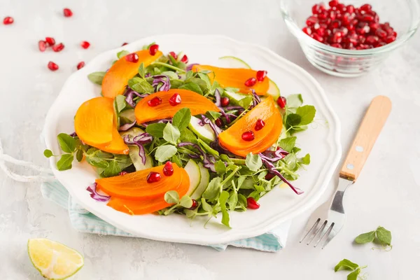 Kaki salade met pea bladeren, komkommer en granaatappel in whi — Stockfoto