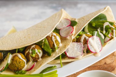 Vegan falafel sebze ve tortilla üzerinde tahin sosu ile