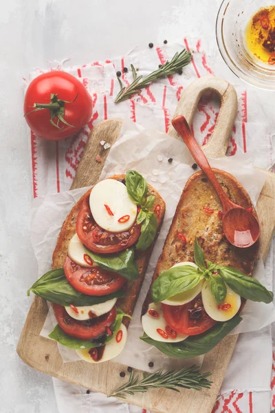 Капрезский сэндвич с моцареллой, помидорами и базиликом на деревянном соусе — стоковое фото