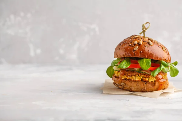 Vegan lentils burger with vegetables and curry sauce. Light back