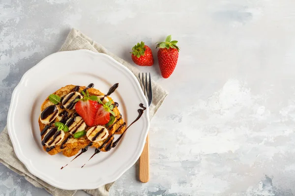 French toasts with chocolate syrup, strawberries and banana. Gra — Stock Photo, Image