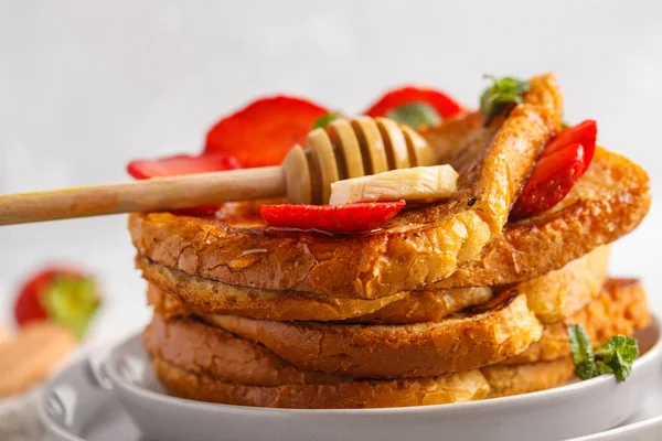 French toasts with honey, banana and strawberries on gray plate. — Stock Photo, Image