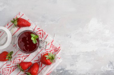 Çilek, gri arka plan ile cam kavanozda çilek reçeli