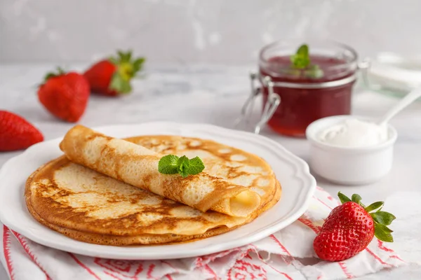 Dünne heiße Pfannkuchen mit Quark, Marmelade und Erdbeeren. — Stockfoto