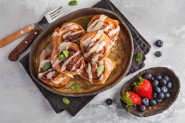 Karanlık bir yemek, açık renkli sır içinde ev yapımı tarçınlı çörek