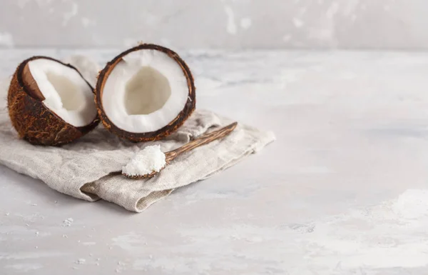 Coco aberto com aparas de coco em uma colher de madeira . — Fotografia de Stock