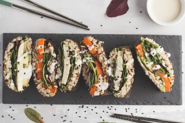 Vegan sushi sandwich onigirazu with tofu and vegetables.