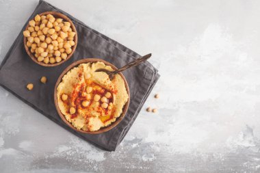 Humus, taze havuç dilimleri ve ahşap kase haşlanmış nohut