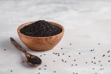 Nigella sativa veya ahşap kase beyaz arka planda siyah kimyon