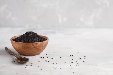 Nigella sativa veya ahşap kase beyaz arka planda siyah kimyon