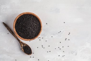 Nigella sativa veya ahşap kase beyaz arka planda siyah kimyon