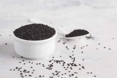 Nigella sativa veya siyah kimyon beyaz arka plan üzerinde beyaz kase,