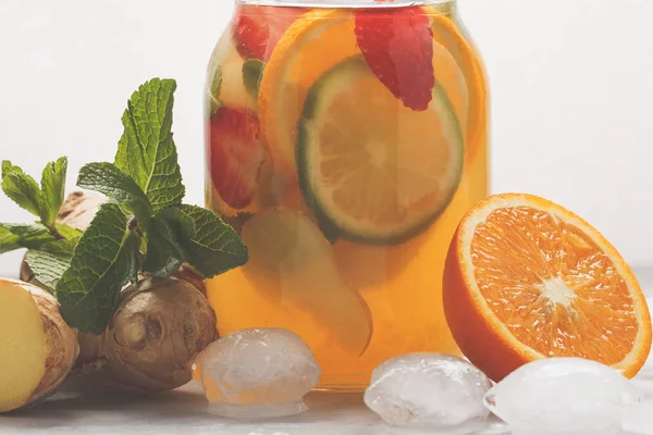 Имбирный фруктовый чай со льдом с мятой в стеклянной банке, белый фон — стоковое фото