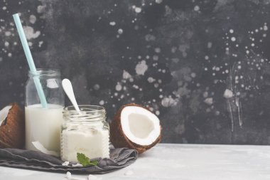 Hindistan cevizi yoğurt ve Hindistan cevizi sütü bir cam kavanoza. Sağlıklı vegan f