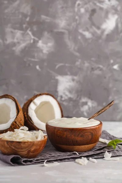 Iogurte de coco em uma tigela de madeira em um fundo escuro, espaço de cópia — Fotografia de Stock