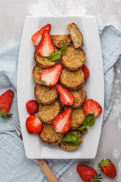 Vegan sweet tofu fritters with strawberries, top view, vertical.