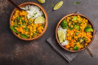 Koyu bir backg tarihinde ahşap kase vegan tatlı patates nohut köri