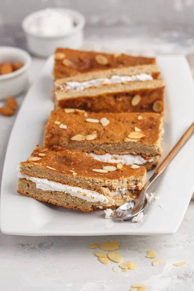 Vegan cake with coconut cream and almonds. Light background