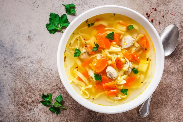 Kuřecí nudlová polévka s petrželkou a zeleninou v bílém talíři — Stock fotografie