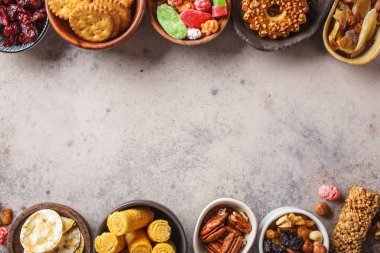 Variety of snacks and sweets on gray background. 