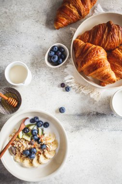 Meyve ve kruvasanla müsli kahvaltıda düzdü. Kopya alanı, gri arka plan..
