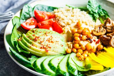 Quinoa, humus, nohut, avokado, sebze ve mantarlı vejetaryen yemek kasesi. Sebzeli ve humuslu kinoa salatası..