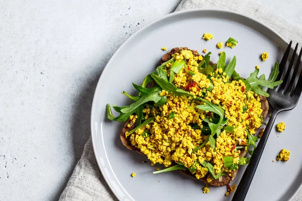 Tofu scramble toast with green onion on rye bread, copy space. Healthy vegan food concept.