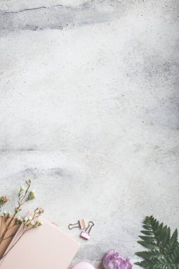 Kadın işyeri. Gri arkaplanda not defteri ve çiçekler, boşluğu kopyala.