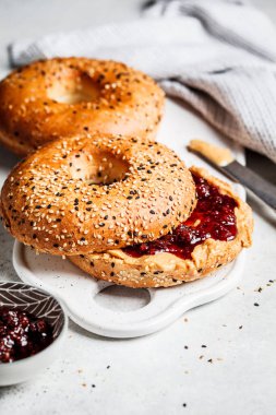 Beyaz tahtada fıstık ezmeli ve çilekli simit. Vejetaryen gıda konsepti.