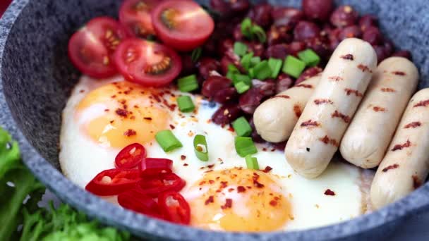 Jedzenie smażonych jaj, kiełbasek i fasoli - śniadanie na patelni. Domowej roboty koncepcja śniadania. — Wideo stockowe