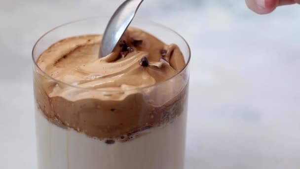 Caffè dalgona coreano freddo. Bevanda con latte freddo e schiuma di crema di caffè in vetro . — Video Stock