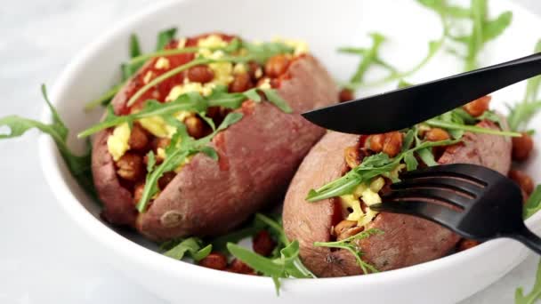 Comer batatas al horno rellenas de garbanzos fritos y queso vegano sobre fondo blanco. Concepto de comida vegetariana saludable . — Vídeos de Stock