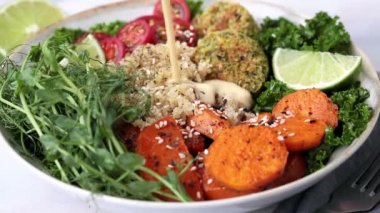 Kinoa soslu salata, fırında patates, falafel, lahana ve bezelye tohumu..