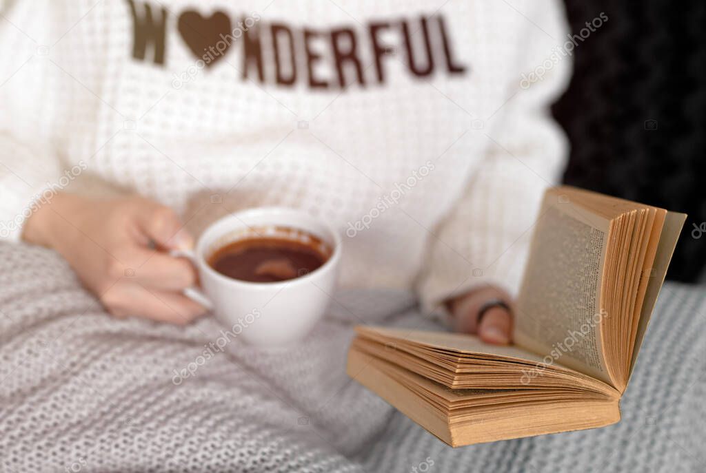 Woman with book and coffee. Stay at home concept